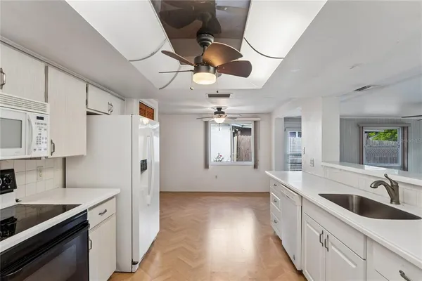 a kitchen with granite countertop a sink stainless steel appliances and cabinets