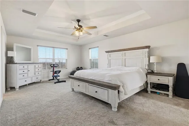 a spacious bedroom with a bed and a chandelier