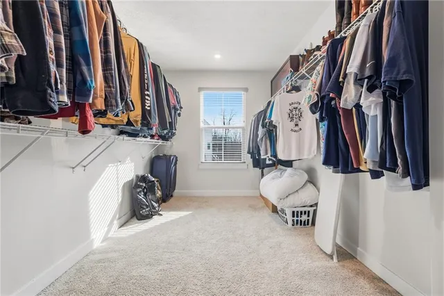 a view of walk in closet with clothes and shoes