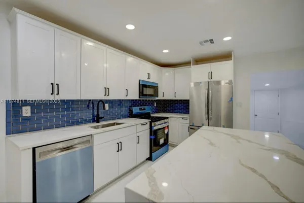 a kitchen with a sink stainless steel appliances and cabinets