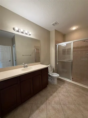 a spacious bathroom with a double vanity sink toilet and a mirror