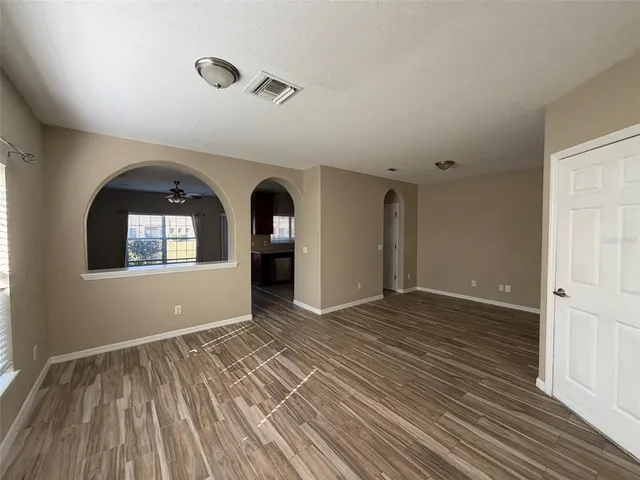 a view of empty room with wooden floor