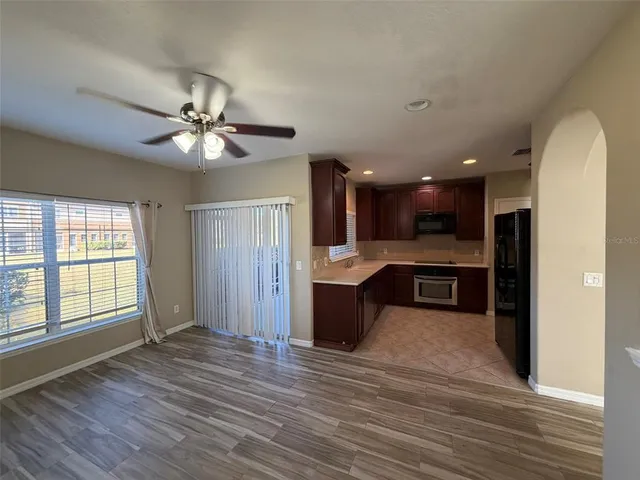 a view of kitchen with kitchen island stainless steel appliances wooden floor and window
