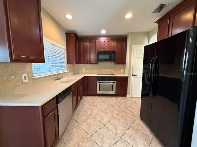 a kitchen with stainless steel appliances granite countertop a sink counter space cabinets and a large window
