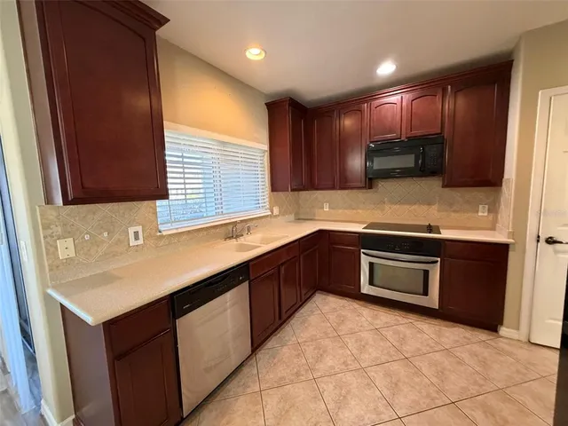 a kitchen with stainless steel appliances granite countertop wooden cabinets a sink and dishwasher