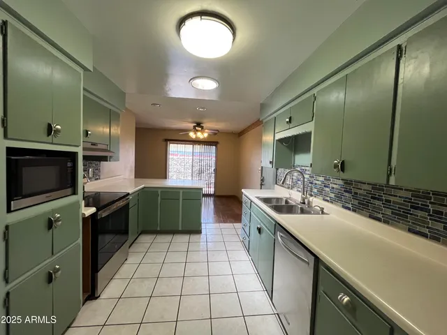 a large kitchen with a large counter top a sink and cabinets