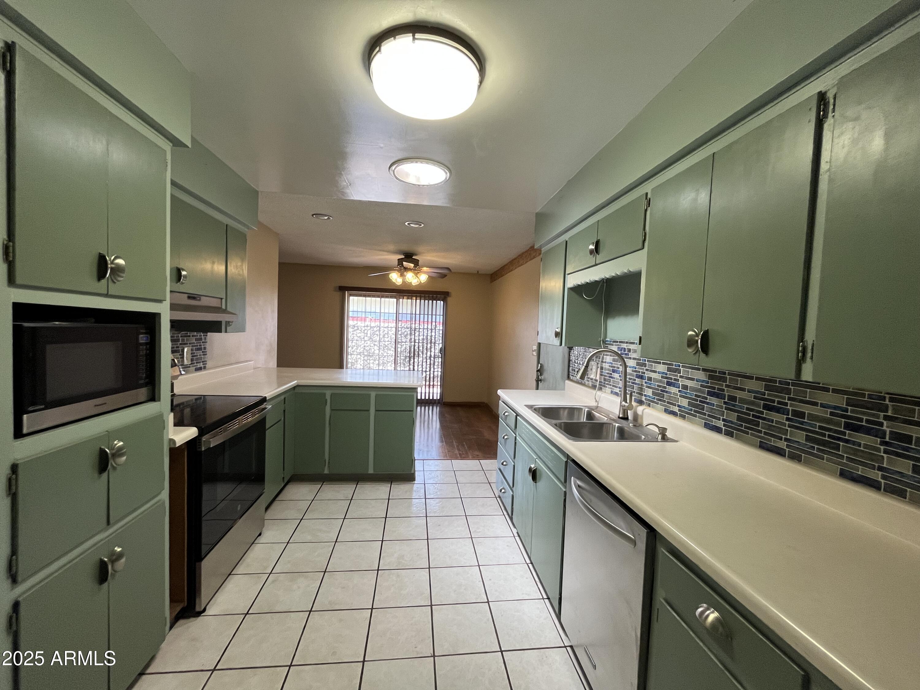 a large kitchen with a large counter top a sink and cabinets