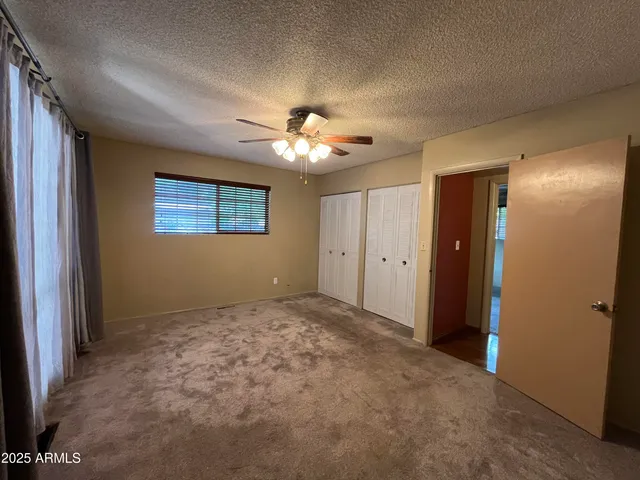 a view of an empty room with a chandelier fan