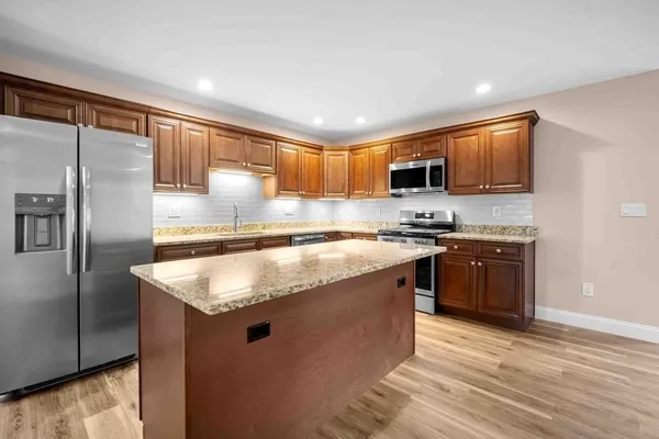 a kitchen with stainless steel appliances granite countertop a sink stove and refrigerator