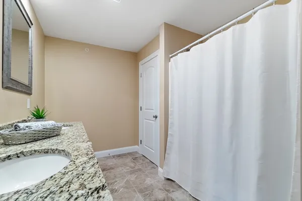 a bathroom with a granite countertop sink and a mirror