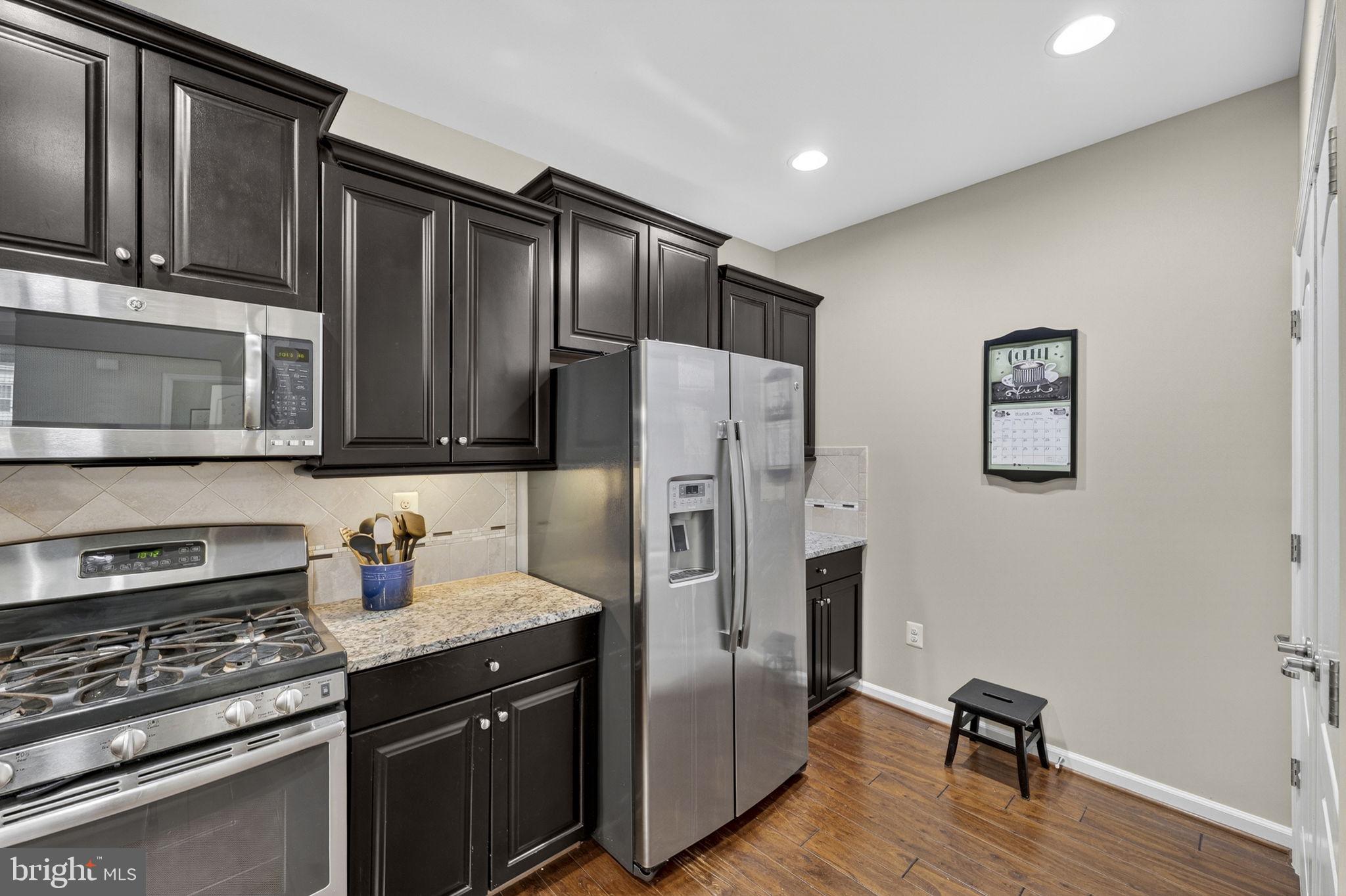 42558 Sunset Ridge Square Ashburn, VA 20148 - Photo 18 of 51 a kitchen with stainless steel appliances granite countertop a refrigerator and a stove top oven