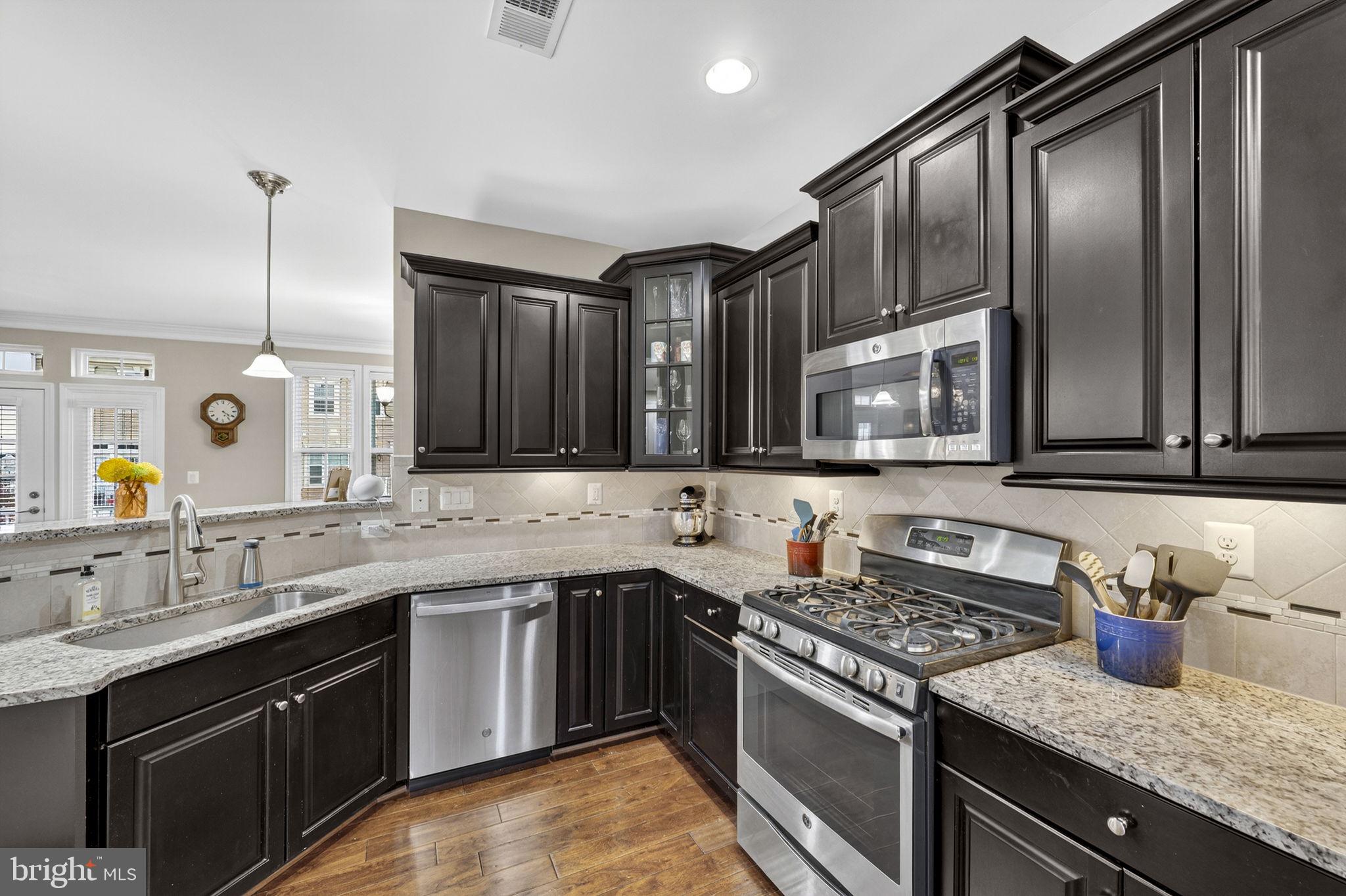 42558 Sunset Ridge Square Ashburn, VA 20148 - Photo 20 of 51 a kitchen with stainless steel appliances granite countertop a sink stove and cabinets