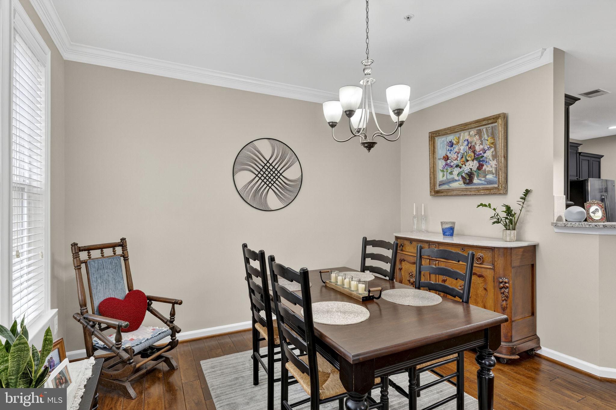 42558 Sunset Ridge Square Ashburn, VA 20148 - Photo 23 of 51 a view of a dining room with furniture a chandelier and wooden floor
