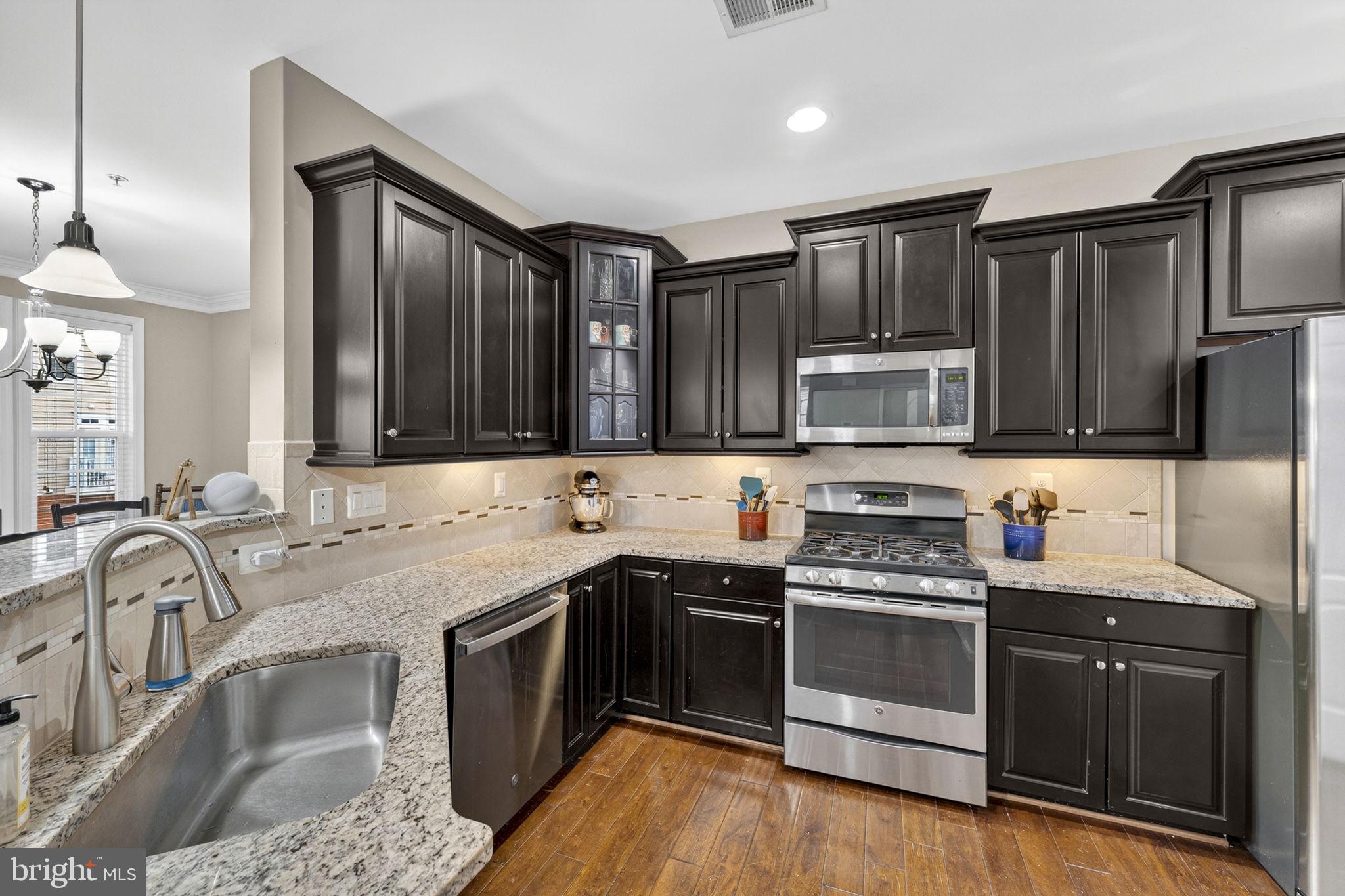 42558 Sunset Ridge Square Ashburn, VA 20148 - Photo 3 of 51 a kitchen with stainless steel appliances granite countertop a sink stove and refrigerator