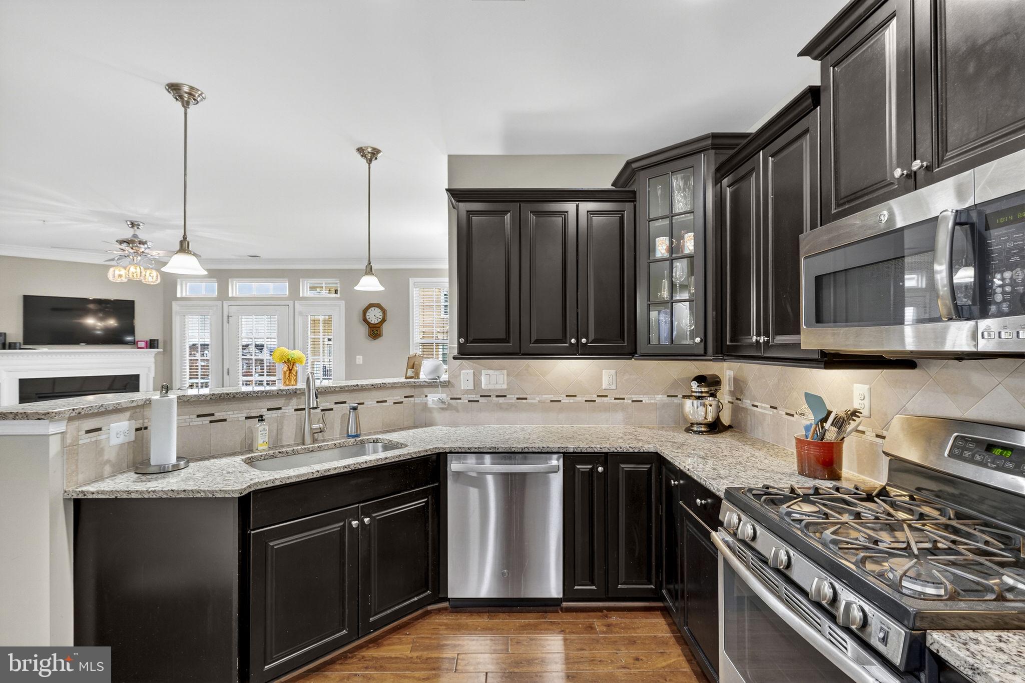 42558 Sunset Ridge Square Ashburn, VA 20148 - Photo 4 of 51 a kitchen with stainless steel appliances a sink stove and cabinets