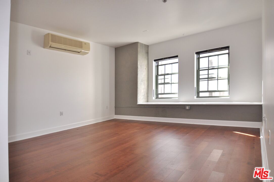 416 South Spring Street, Unit 805 Los Angeles, CA 90013 - Photo 15 of 24 an empty room with wooden floor and windows