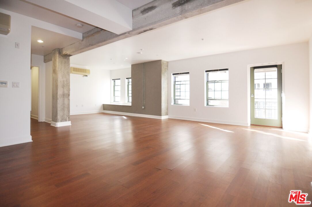 416 South Spring Street, Unit 805 Los Angeles, CA 90013 - Photo 2 of 24 a view of an empty room with wooden floor and a window