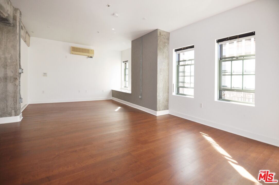 416 South Spring Street, Unit 805 Los Angeles, CA 90013 - Photo 3 of 24 an empty room with wooden floor and windows