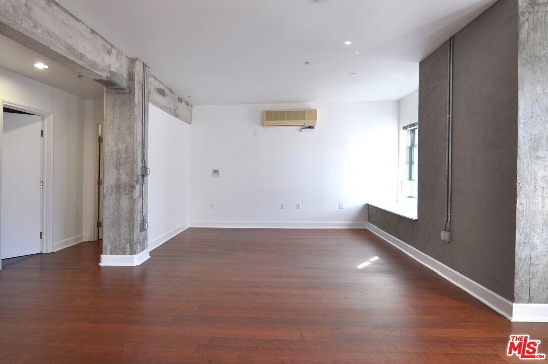 416 South Spring Street, Unit 805 Los Angeles, CA 90013 - Photo 4 of 24 an empty room with wooden floor and windows