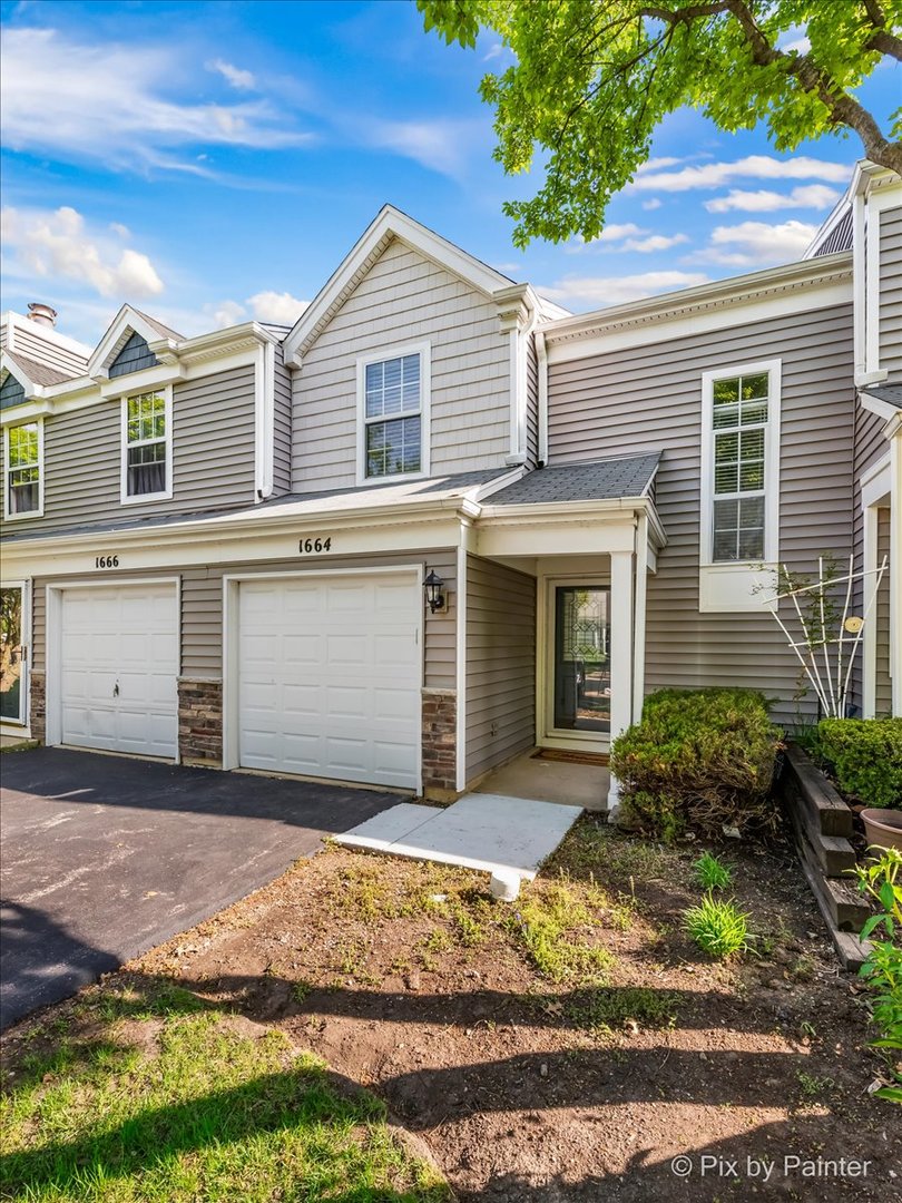 1664 Pebble Beach Circle Elgin, IL 60123 - Photo 2 of 24 a front view of a house with a yard and garage