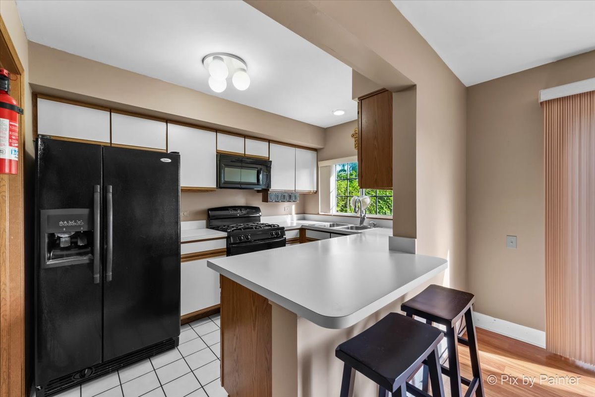 1664 Pebble Beach Circle Elgin, IL 60123 - Photo 7 of 24 a kitchen with a refrigerator a stove a sink and a microwave