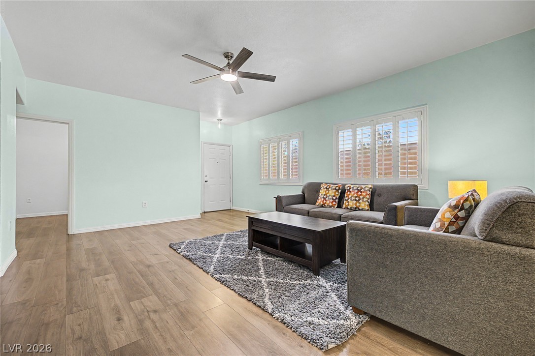 2153 Quarry Ridge Street, Unit 103 Las Vegas, NV 89117 - Photo 14 of 42 Hardwood floors and bright windows create an inviting and well-lit gathering space.