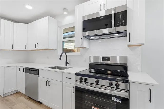 a kitchen with stainless steel appliances a stove a microwave and cabinets