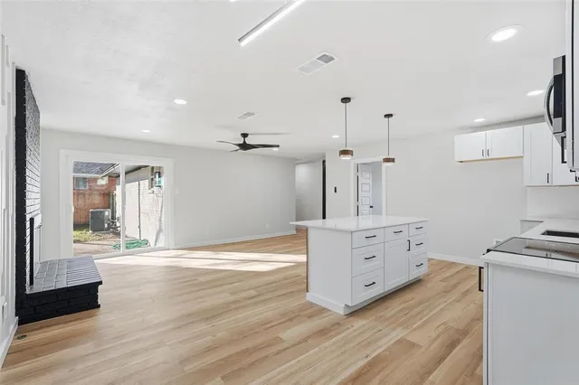 a room with wooden floors and white cabinets