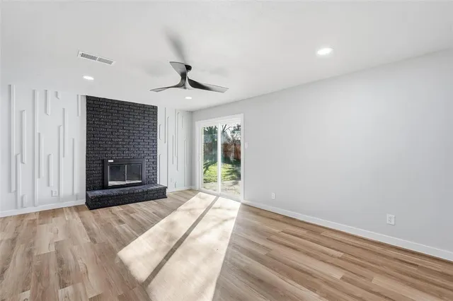 a view of an empty room with a fireplace and a window