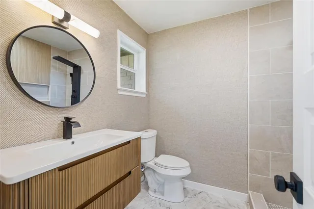 a bathroom with a sink a toilet and a mirror