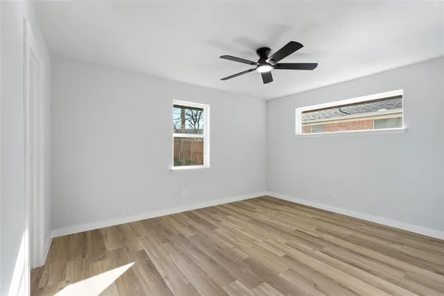 a view of empty room with wooden floor