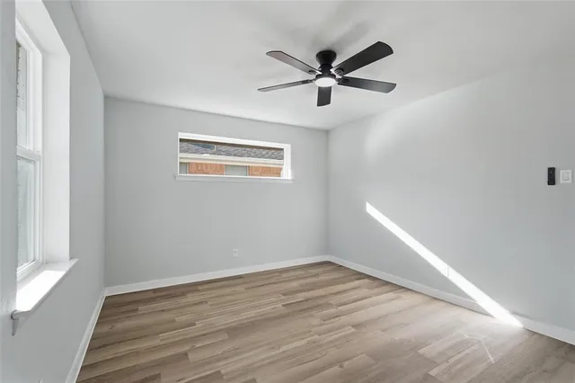 a view of a big room with wooden floor and windows