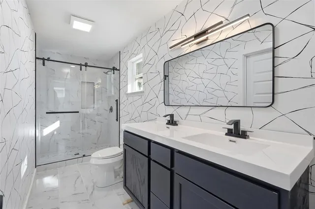 a bathroom with a sink toilet a mirror and shower