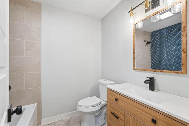 a bathroom with a sink a toilet and a mirror