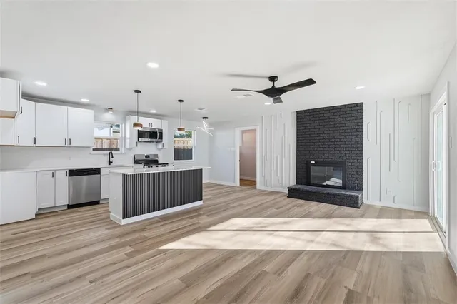 a large kitchen with kitchen island a sink stainless steel appliances and cabinets