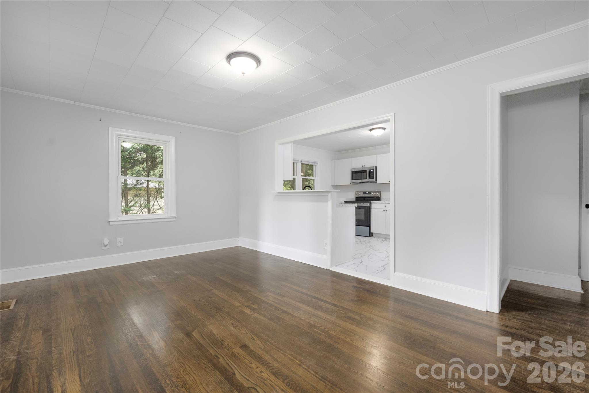 146 Staton Road Gastonia, NC 28056 - Photo 3 of 25 an empty room with wooden floor and windows