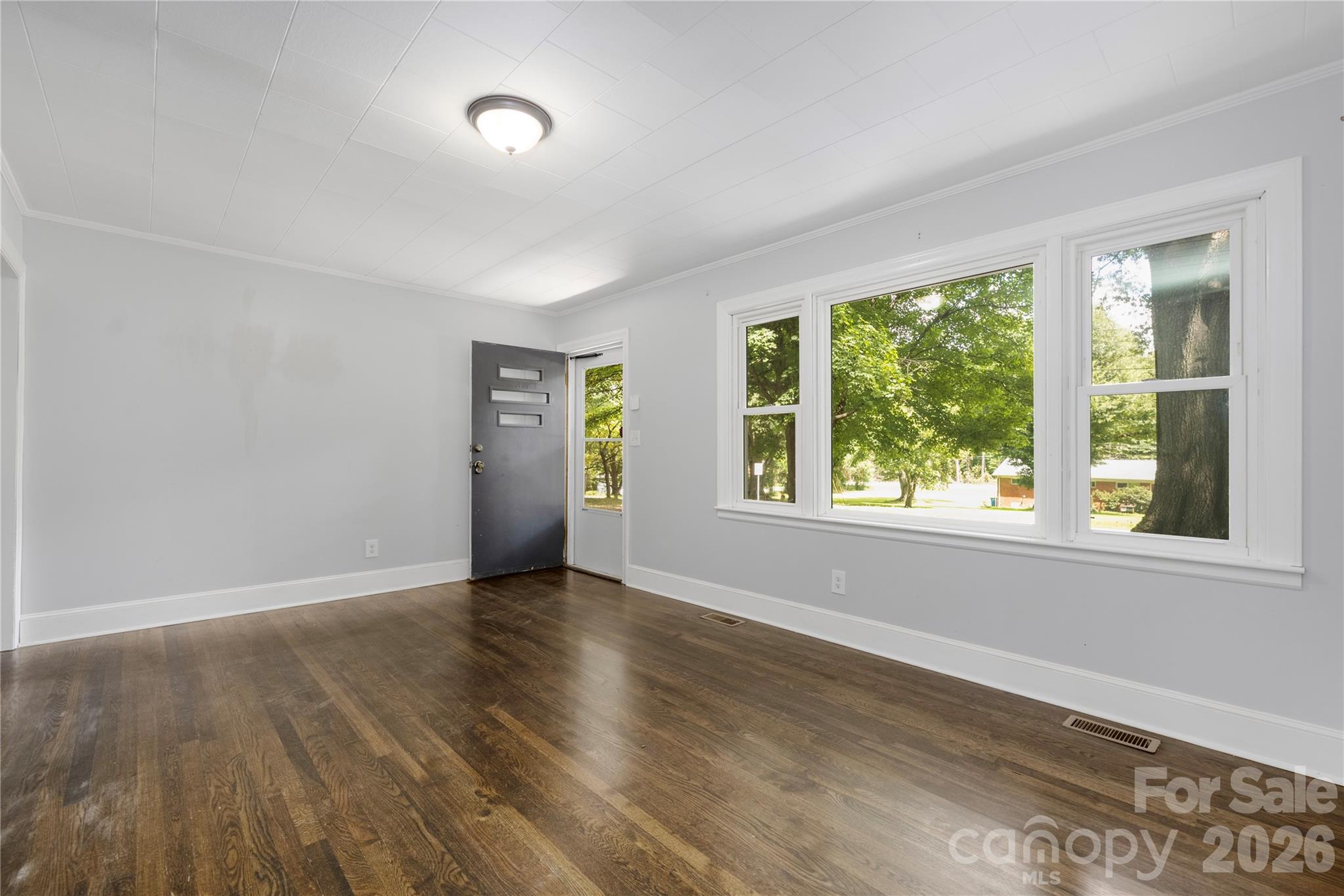 146 Staton Road Gastonia, NC 28056 - Photo 6 of 25 a view of an empty room with wooden floor and a window