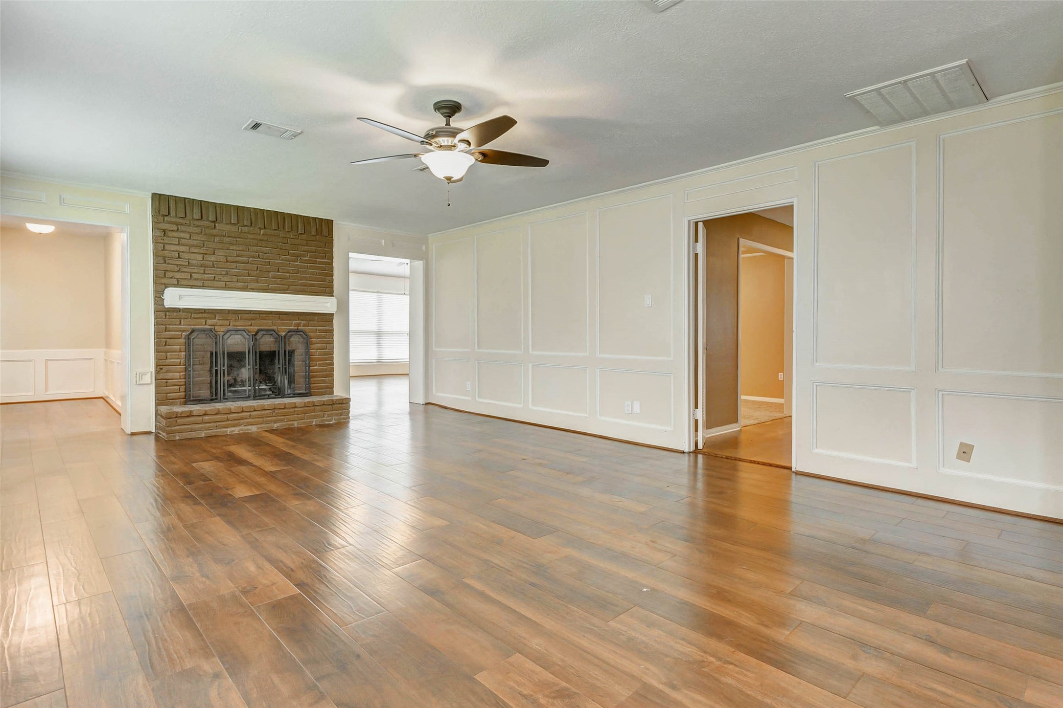 18103 Ravenfield Drive Houston, TX 77084 - Photo 12 of 36 a view of an empty room with wooden floor fireplace and a window