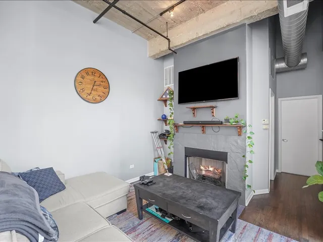 a living room with furniture a flat screen tv and a fireplace