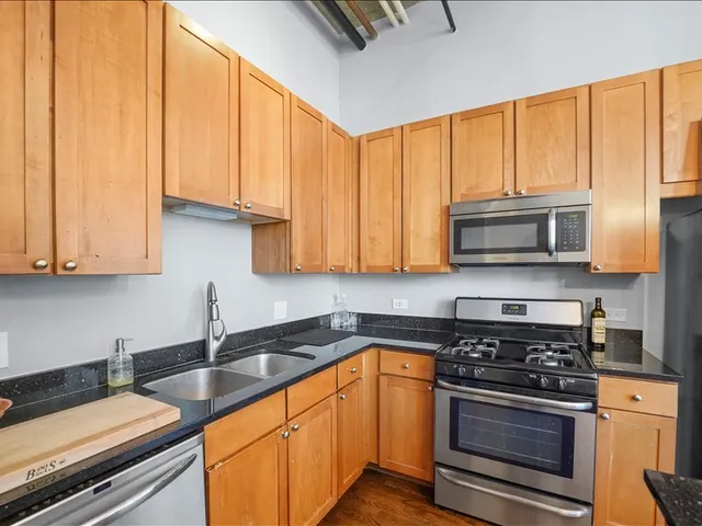 a kitchen with stainless steel appliances granite countertop a stove a sink and a microwave