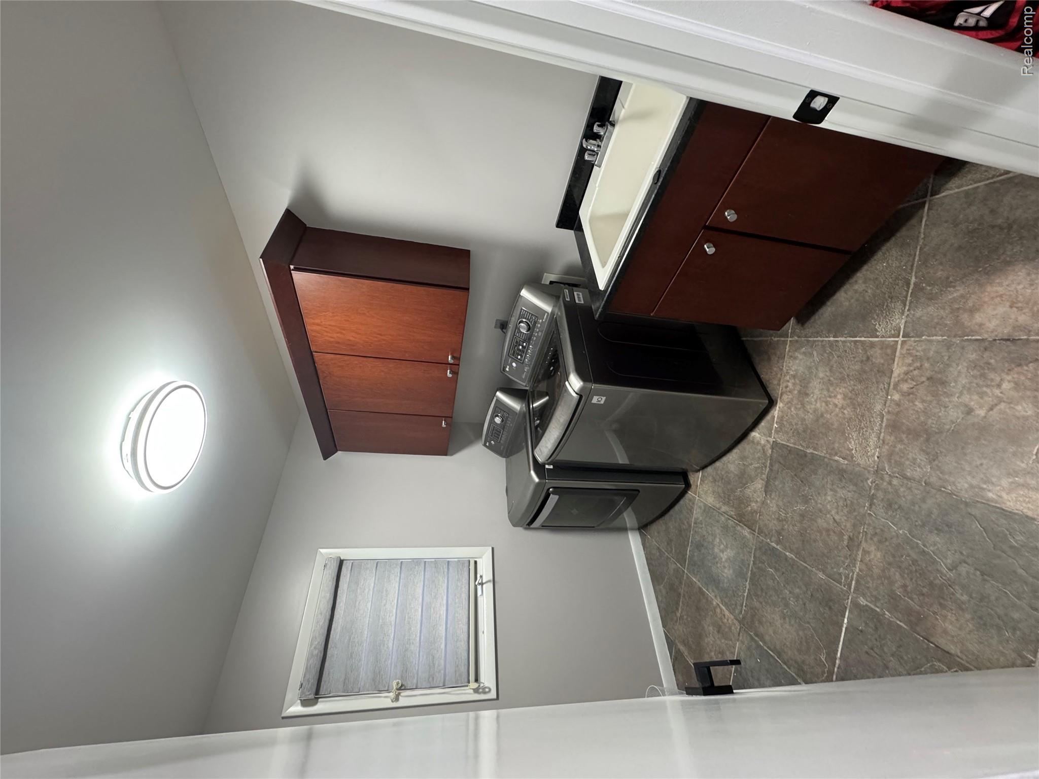 50493 Nesting Ridge Drive Macomb, MI 48044 - Photo 32 of 34 Washroom featuring cabinet space, independent washer and dryer, and dark stone finish flooring