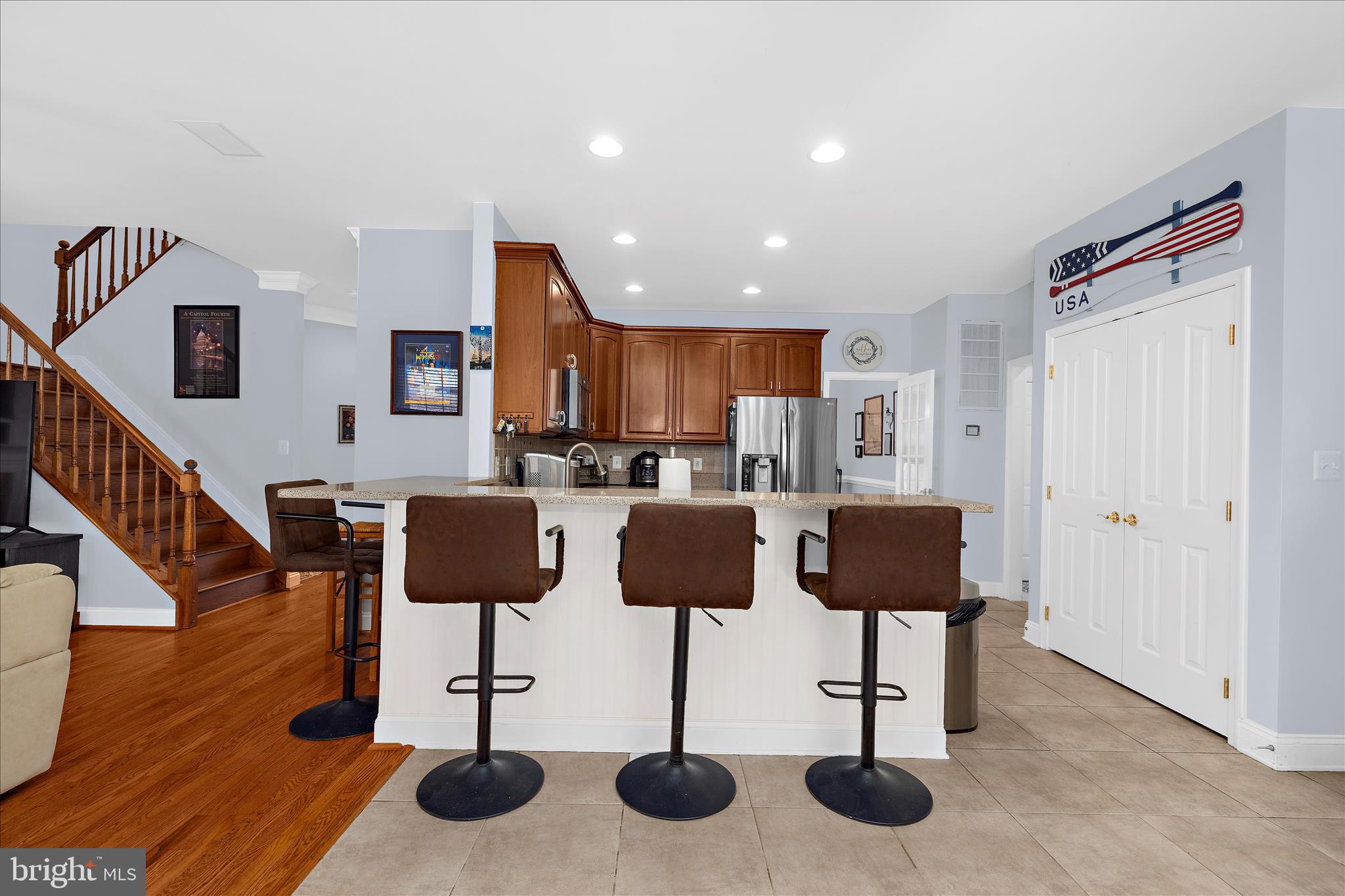 211 Still Water Lane Huntingtown, MD 20639 - Photo 11 of 87 a kitchen with stainless steel appliances kitchen island granite countertop a table chairs and a refrigerator