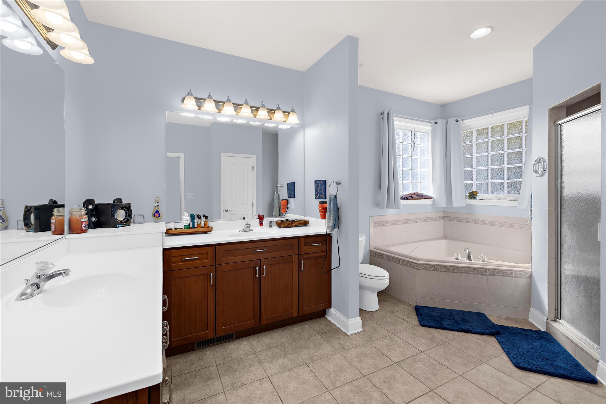 211 Still Water Lane Huntingtown, MD 20639 - Photo 23 of 87 a bathroom with a double vanity sink a toilet a mirror and bathtub