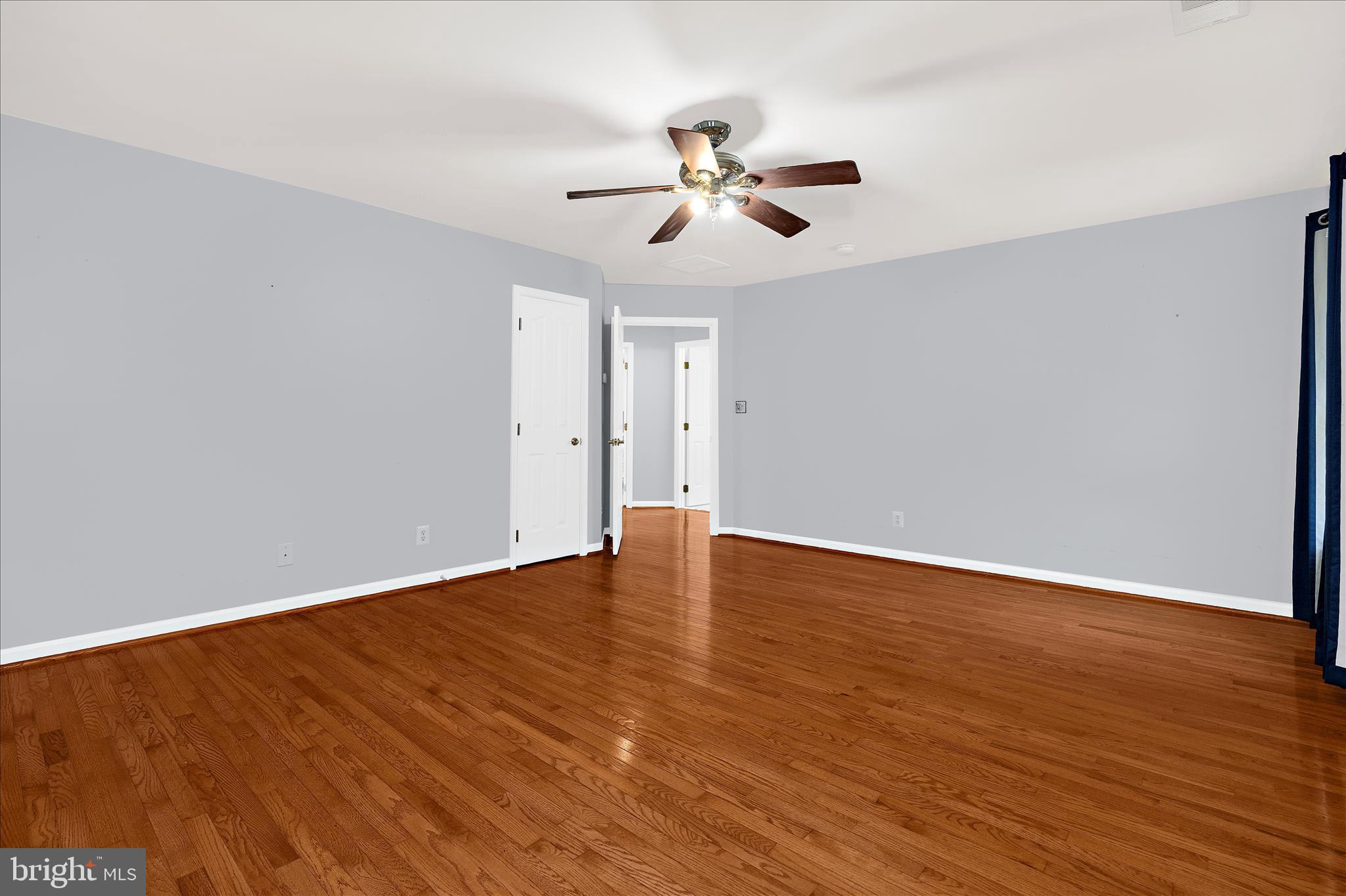 211 Still Water Lane Huntingtown, MD 20639 - Photo 56 of 87 a view of an empty room with wooden floor and a ceiling fan