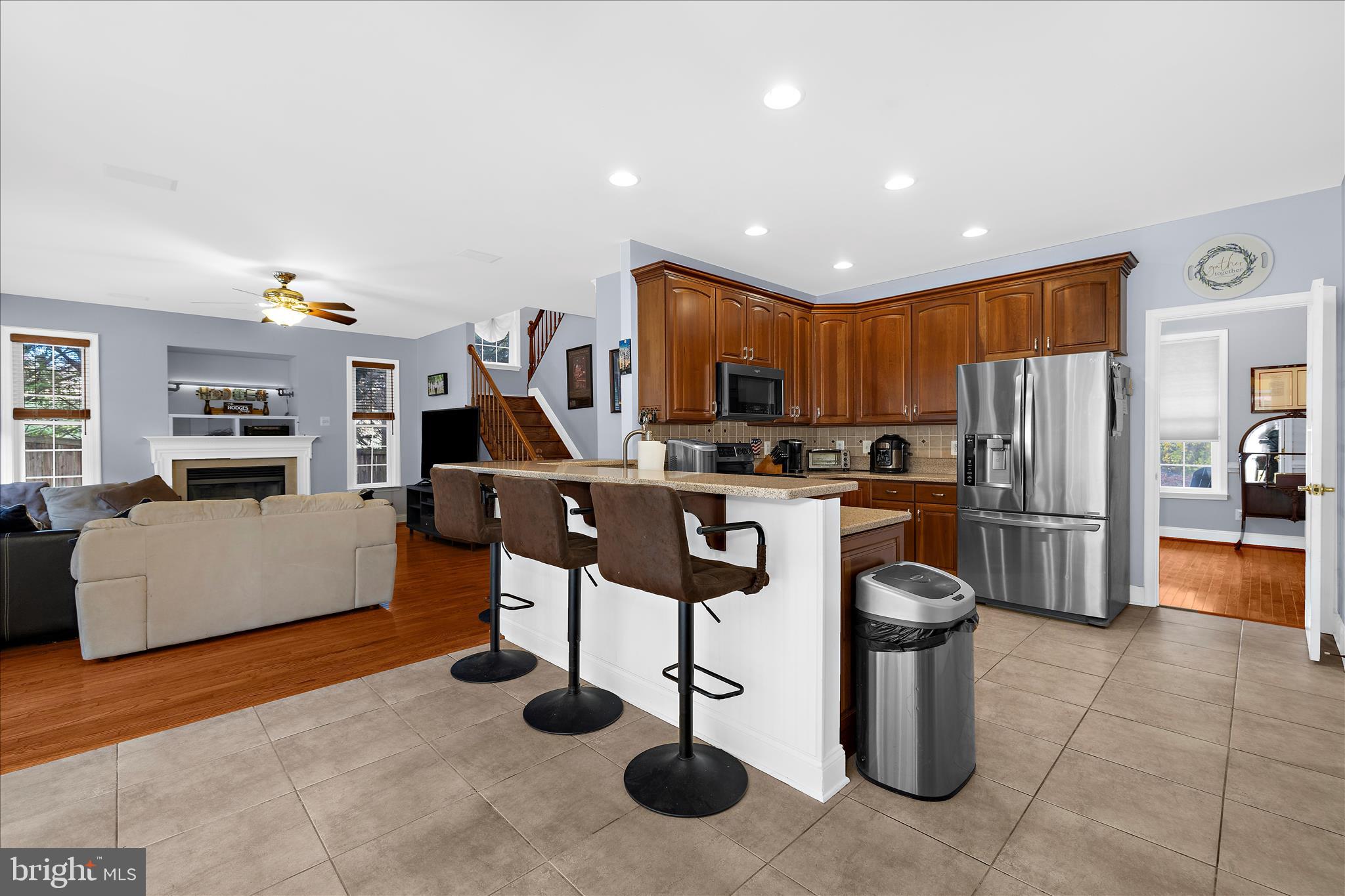 211 Still Water Lane Huntingtown, MD 20639 - Photo 9 of 87 a kitchen with stainless steel appliances kitchen island granite countertop a refrigerator oven a sink a stove a dining table and chairs