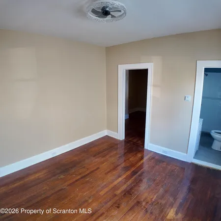 an empty room with wooden floor and closet