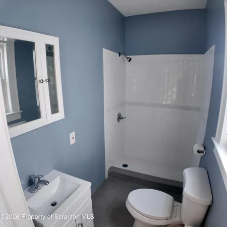 a white toilet sitting next to a bathroom sink