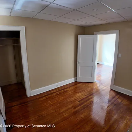 an empty room with wooden floor and closet