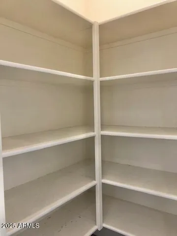 an empty room with a ceiling fan and carpet