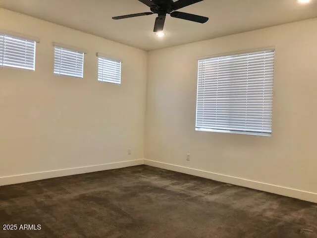 an empty room with a ceiling fan and a window